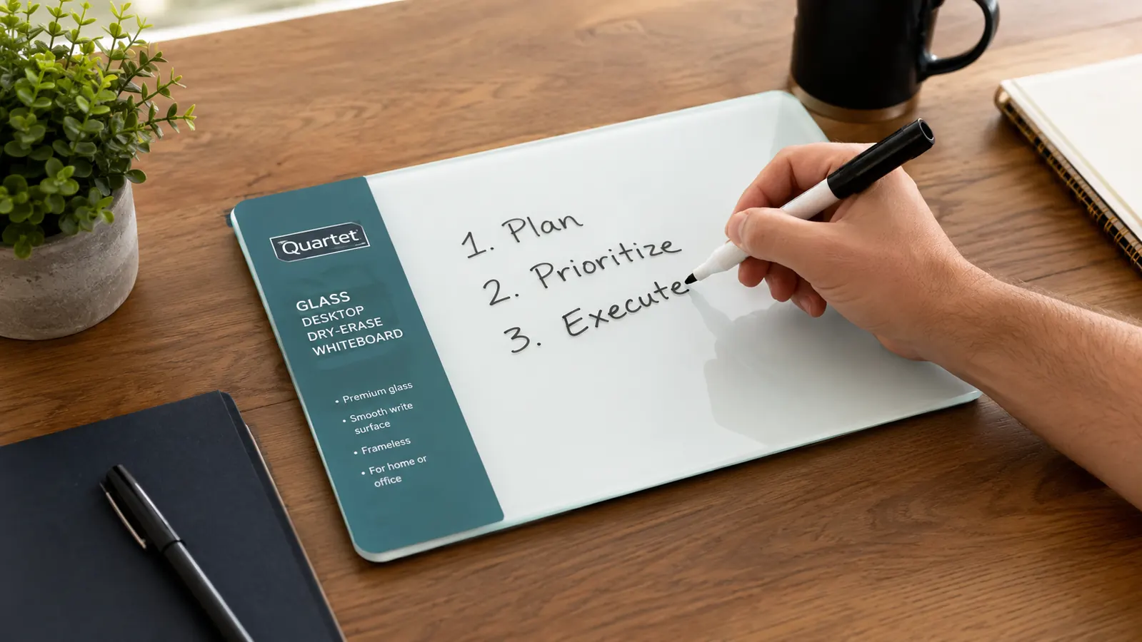 Hand writing a daily task list on the glass desktop whiteboard with a dry erase marker
