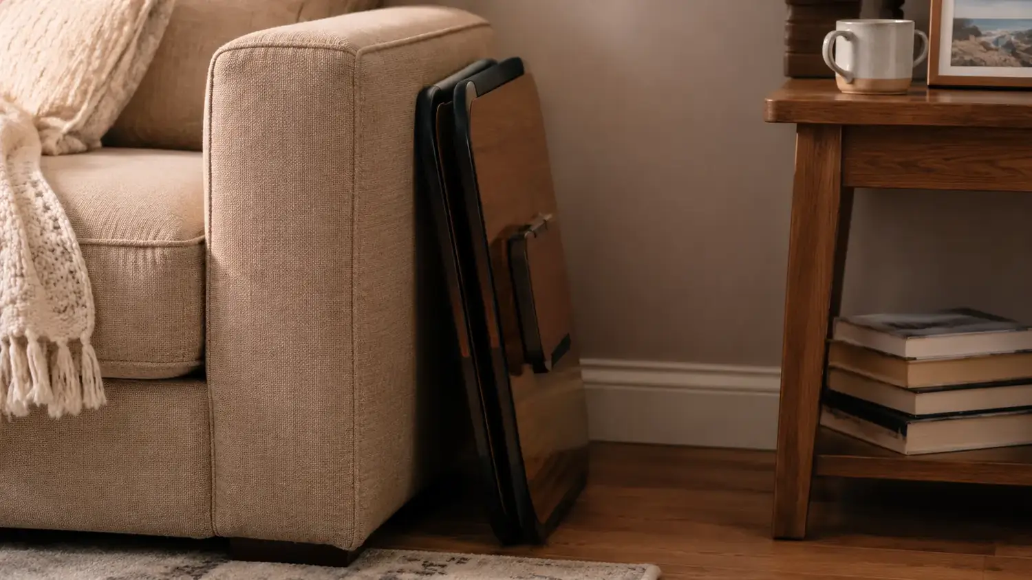 Adjustable lap desk with tilted top and side legs folded flat, sitting empty on a couch cushion